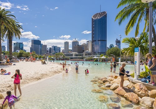 The Streets Beach on a busy day, with Brisbane city in the background