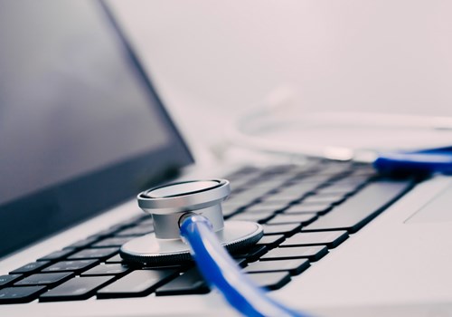 A stethoscope placed on top of a laptop