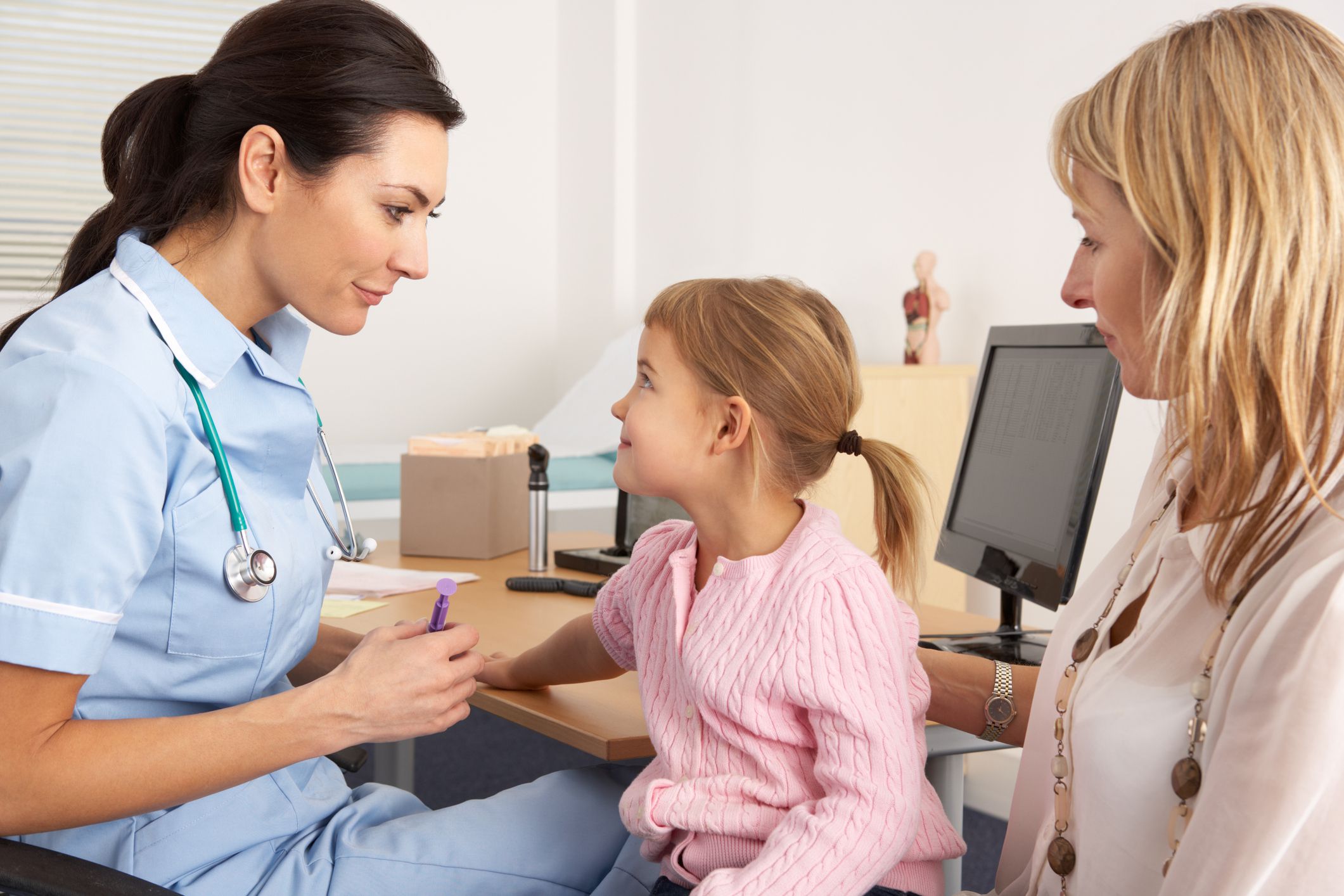 A female doctor talking to a mother and her child