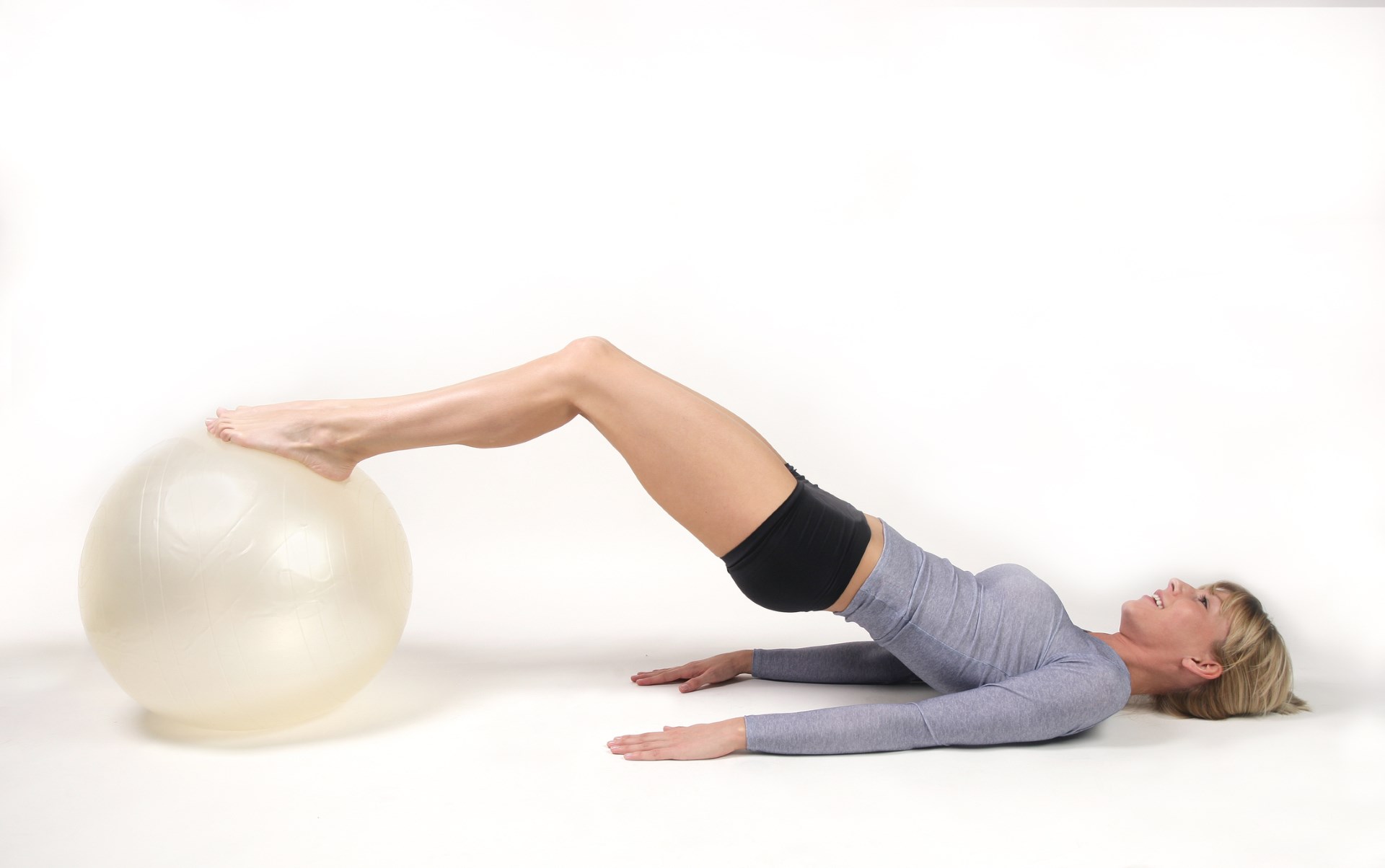 A woman using an exercise ball to stretch