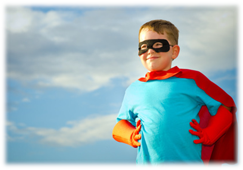 A child wearing a super hero outfit with his hands on his hips